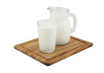 Milk in pitcher and glass on wooden board isolated