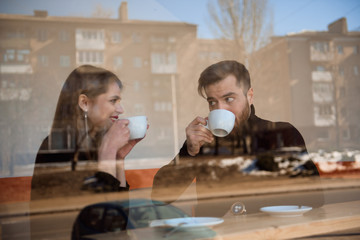 Good looking couple laughing and having a good time on a date in a coffee shop