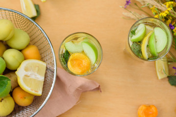 Summer lemonade with lemon, lime, ginger, with wildflowers on the table. Cooling drinks