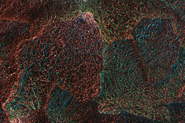 abstract background of glossy silver textured ragged foil with colorful illumination