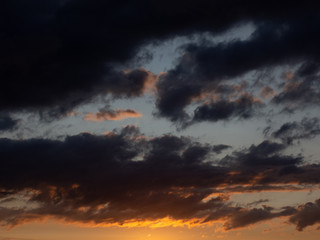Fototapeta na wymiar Beautiful dark clouds at sunset. The evening sky during sunset.