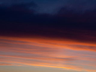 Naklejka na ściany i meble Beautiful dark clouds at sunset. Evening sky at sunset time.