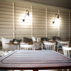 Obraz na płótnie Canvas Wooden table background with blurred restaurant view. Empty space for advertising product and decoration.