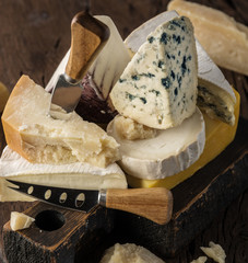 Assortment of different cheese types on wooden background. Cheese background.