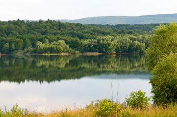 beautiful summer lake against the background of high mountains and blue sky