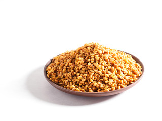 Fenugreek (Trigonella) on a clay plate on a white background