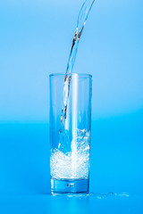 Close up pouring purified fresh drink water from the bottle on table