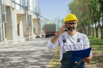 worker using cellphone while controlling grain load in factory