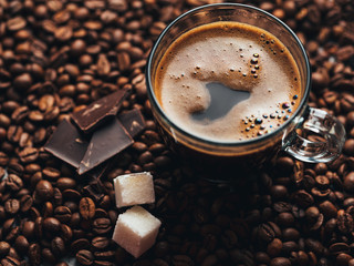 Glass Cup espresso coffee with chocolate on coffee beans
