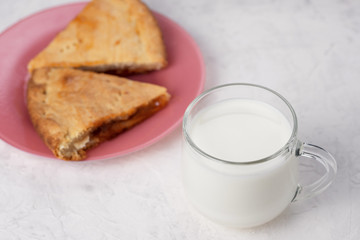 homemade cake with jam and a Cup of milk on the table