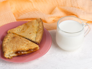 homemade cake with jam and a Cup of milk on the table