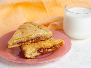 homemade cake with jam and a Cup of milk on the table