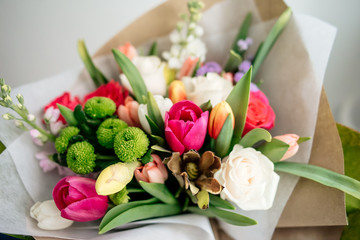 bouquet of tulips and roses. orange, green, white and red flowers. close up