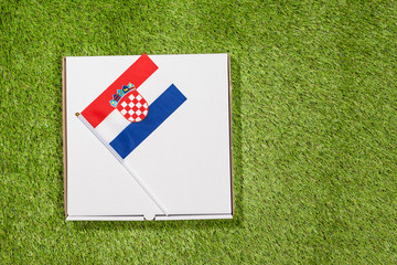 Paper box of pizza with Croatian Flag on the grass. Concept. Top view