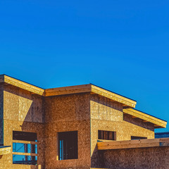 Exterior of a house under construction against clear blue sky on a sunny day