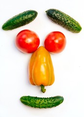 peppers, tomatoes and cucumbers on a white background. smile with vegetables