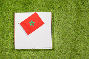 Paper box of pizza with iranian Morocco on the grass. Concept. Top view
