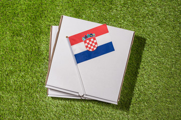 Paper box of pizza with Croatian Flag on the grass. Concept. Top view