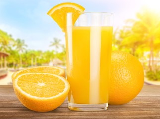 Glass of delicious orange juice on table