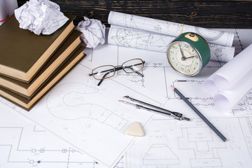 Several tools for drawing, glasses and retro clock lying in the drawings
