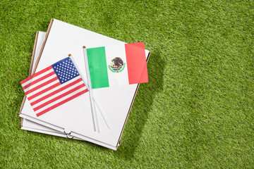 Paper box of pizza with flags of Mexico and America on the grass. Concept of peace, partnership and friendship, . Top view