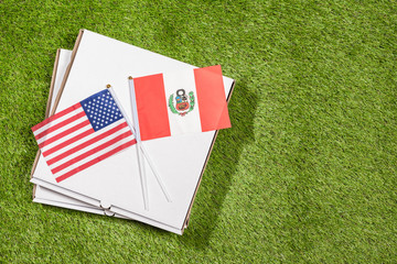 Paper box of pizza with flags of Peru and America on the grass. Concept of peace, partnership and friendship, . Top view