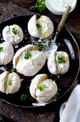 Whole baked potatoes with curd sauce and herbs