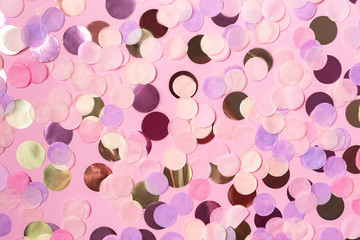 Pink background with colorful round paper confetti. Copy space. Holiday concept.