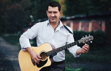 Man is playing guitar on a street