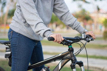 close up shot of hijab  woman's hand was holding the wheel of a bicycle in a park