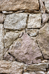 Detail of an old stone wall arranged in an irregular manner. Architecture constructions. Vintage background.