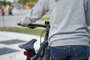 close up shot of hijab  woman's hand was holding the wheel of a bicycle from behind in a park