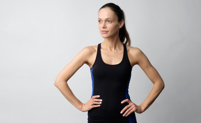 Sporty pretty woman is wearing sport clothes isolated on grey background