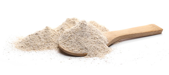 Barley flour pile with wooden spoon isolated on white background