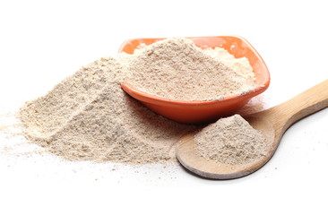 Barley flour pile with wooden spoon and porcelain bowl isolated on white background
