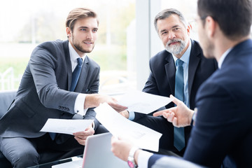 Group of business partners discussing ideas and planning work in office.