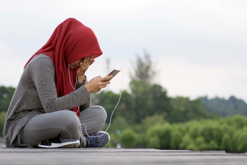 close-up shot of hjab women listening to music using a headset while sad
