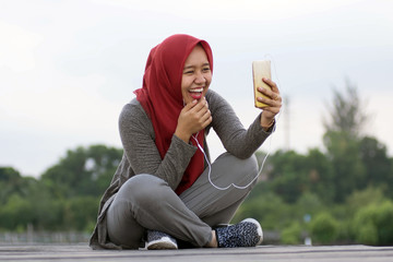 portrait of hijab woman sitting on the boardwalk in the sunshine of a beautiful mangrove garden...