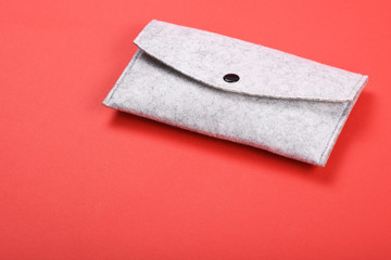 Felting wallet on the red background with copy space