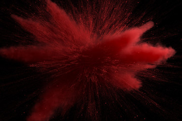 3d illustration of red colored powder explosion isolated on black background.