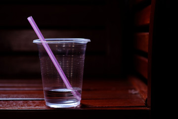 Plastic glass on the wood chair in the room
