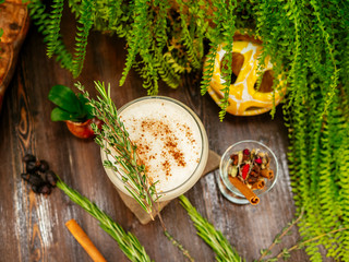 Brown cocktail in a glass goblet on a long leg. In the tropical garden. On a flat stone.