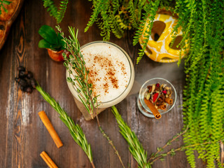 Brown cocktail in a glass goblet on a long leg. In the tropical garden. On a flat stone.