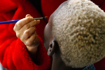 Makeup artist does makeup model. Afro-American models apply makeup