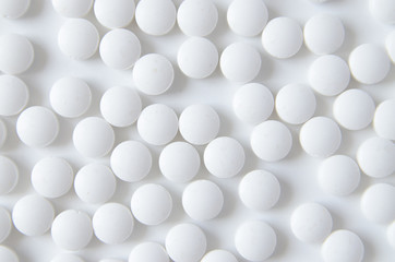 scattered white pills on the white table