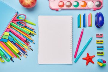 Bright composition from the stationery on a blue background