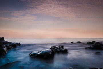 Obraz premium Long exposure image of Dramatic sky and wave with rock sea in sunset scenery background