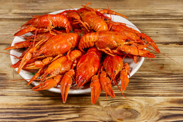 Boiled crayfish in plate on wooden table