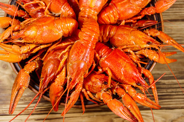 Boiled crayfish in plate on wooden table. Top view