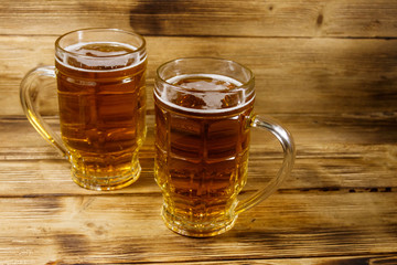 Two mugs of beer on a wooden table
